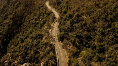 Vue aérienne d'une route en lacets vertigineux serpentant dans un paysage de montagne pour un road trip moto.